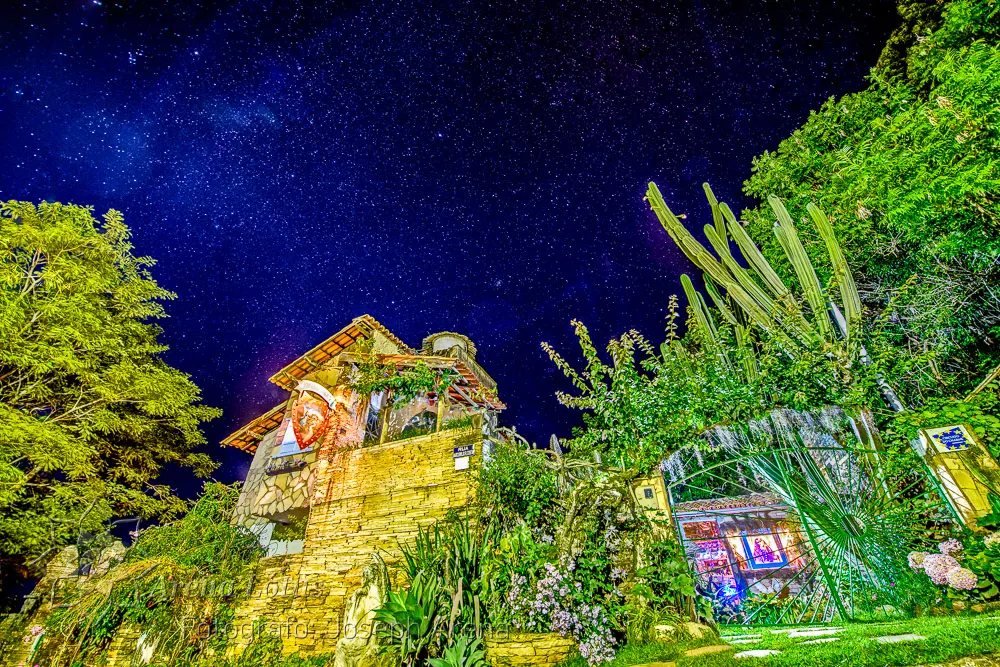 O casarão e a torre iluminados sob um céu estrelado