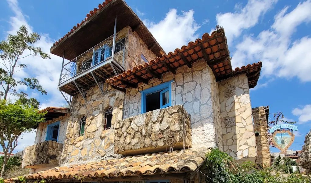 Casarão de pedra quartzito da Pousada dos Anjos, com a torre, janelas azuis e telhado colonial