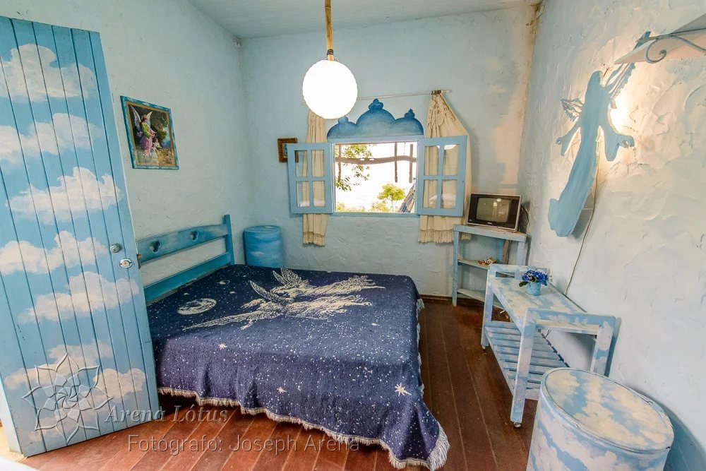 Quarto azul com porta pintada de nuvens e colcha de estrelas